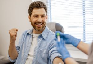 a happy male patient is excited about getting his blood drawn to rule out or possibly treat thyroid conditions.