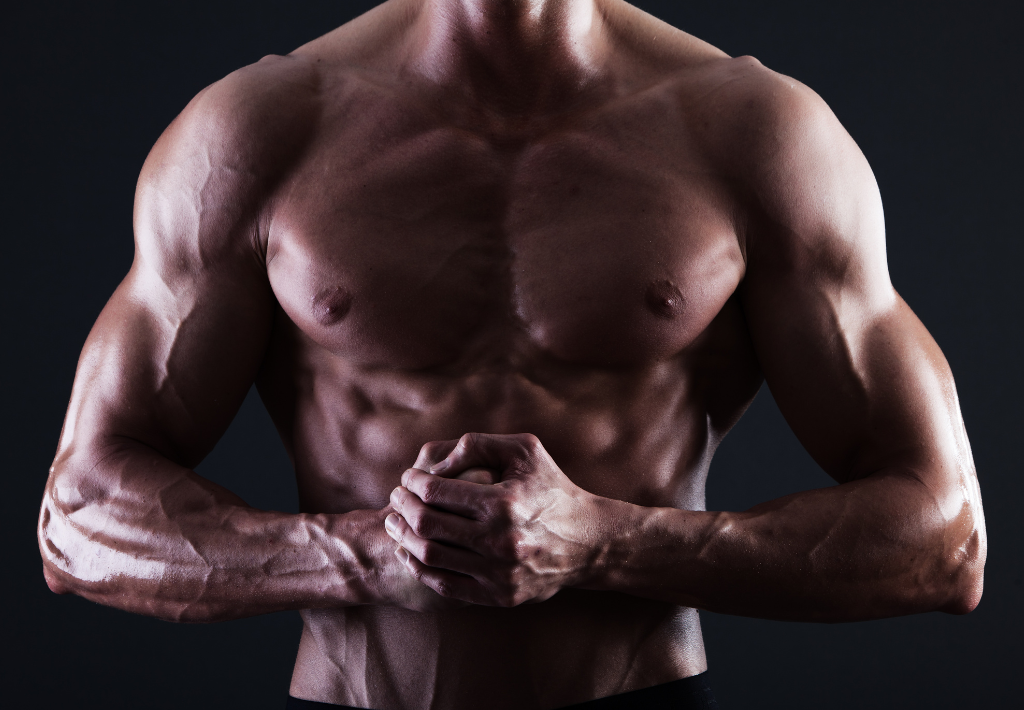an image of a ripped male physique with great muscle definition in this sepia toned image that answers how is testosterone produced in men